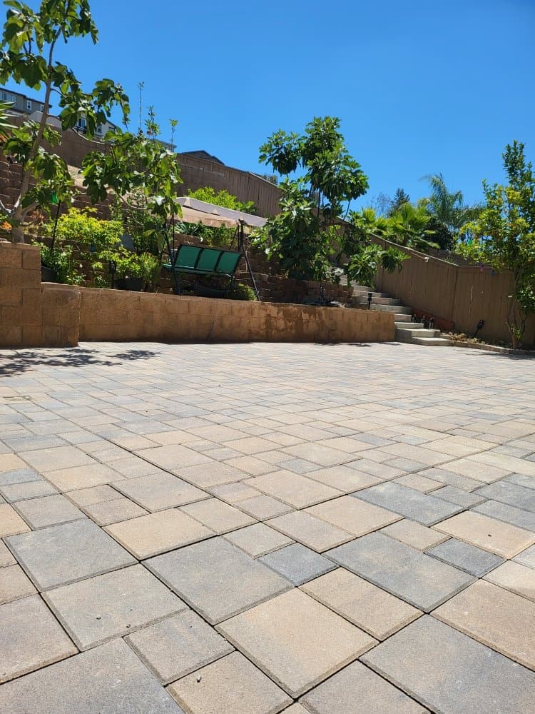 Finished paver patio in a San Diego backyard with even joints and a tan and gray pattern